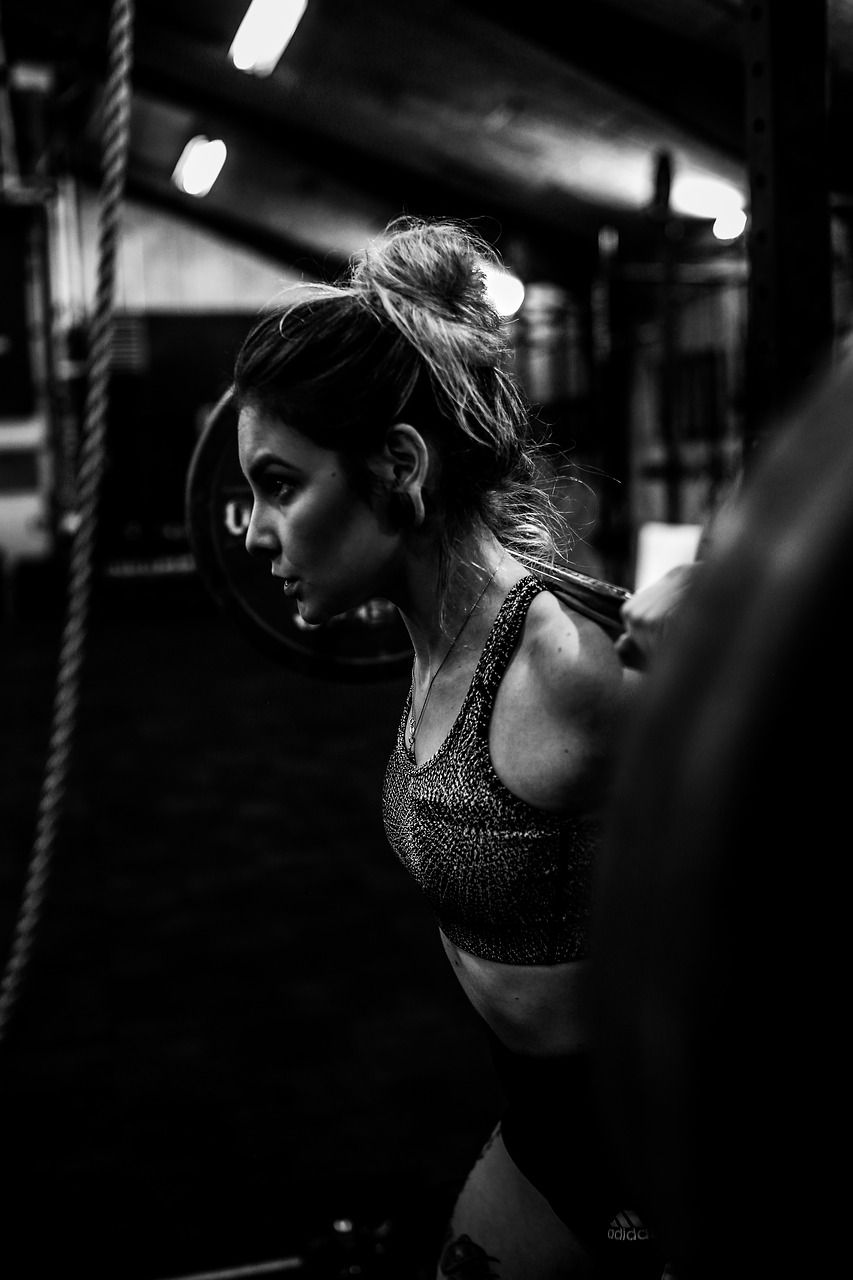 Aluna em treino funcional com peso livre